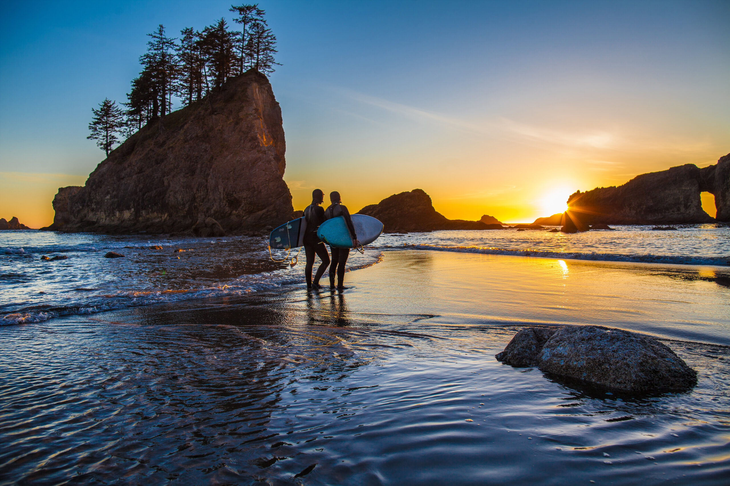 50199855772_74527248a7_o Two surfers holding boards standing at the shoreline at sunset